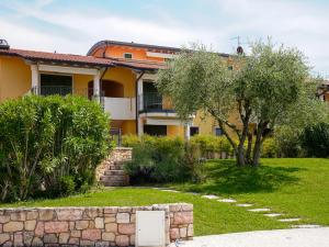 a yellow house with a tree in the yard at New Home Lazise in Lazise