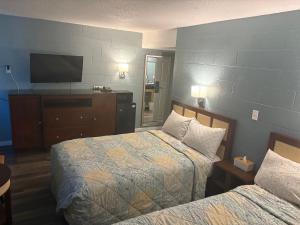 a hotel room with two beds and a flat screen tv at Lamplighter Motel in Longmont