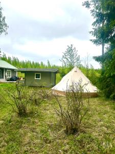 a tent in a yard next to a house at Glamping teltta Venekoski in Hankasalmi