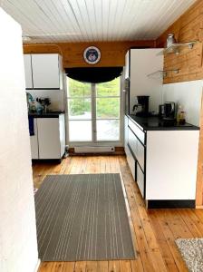 a kitchen with white cabinets and a large window at Glamping teltta Venekoski in Hankasalmi