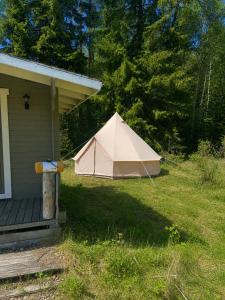 a tan tent sitting on the side of a house at Glamping teltta Venekoski in Hankasalmi +2 photos