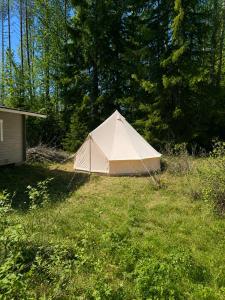 a white tent sitting in the middle of a field at Glamping teltta Venekoski in Hankasalmi