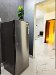a stainless steel refrigerator with a plant on top of it at HideAway in Hyderabad