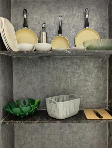a shelf with plates and utensils in a kitchen at HideAway in Hyderabad