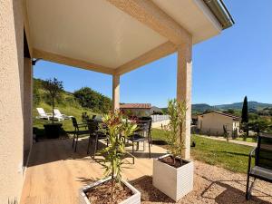 a covered patio with chairs and a table with a view at L'échappée Bourguignonne in La Vineuse