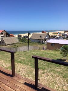 a bench on a deck with a view of the ocean at The Shark in Punta Del Diablo