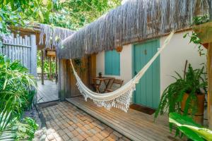 a hammock on the porch of a house at Pousada do Rio Caraíva in Caraíva
