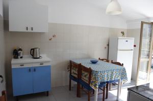 a small kitchen with a table and a refrigerator at Meraviglia in riva al mare in Belmonte Calabro