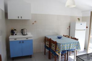 a small kitchen with a table and a refrigerator at Meraviglia in riva al mare in Belmonte Calabro