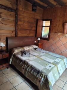a bedroom with a bed in a log cabin at Casa Sabinar in Navajas