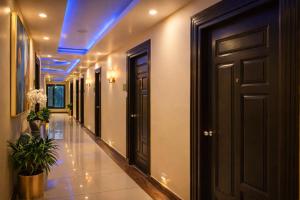 a hallway with black doors and potted plants at Aachman Nature Valley Resort MASHOBRA in Shimla