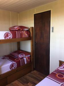 a room with two bunk beds and a door at The Shark in Punta Del Diablo
