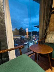 a room with a table and a window with a view at Hosta Inn Hotel and Resort in Edappāl