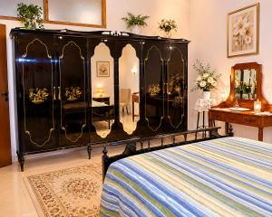 a bedroom with a black bed and a dresser at Valle Verde 4 Clima & Wi-Fi in Castellammare del Golfo