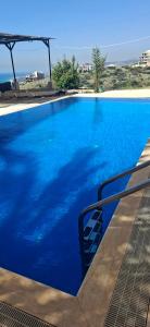 a large blue swimming pool with a clear blue water at Honey Chalet in Al Khayyām