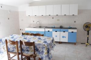 a kitchen with a table and a blue and white kitchen at Paradiso in riva al mare in Belmonte Calabro