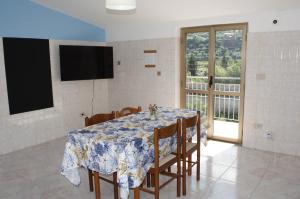 a dining room with a table and a tv and a window at Paradiso in riva al mare in Belmonte Calabro