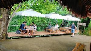 a group of people sitting at tables under white umbrellas at Homestay Hùng Phát Pù Luông in Làng Chiêu +27 photos