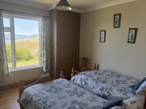 a bedroom with two beds and a large window at St Ann's Rossbeigh in Glenbeigh