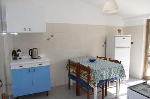 a small kitchen with a table and a refrigerator at Appartamento sul mare in Belmonte Calabro