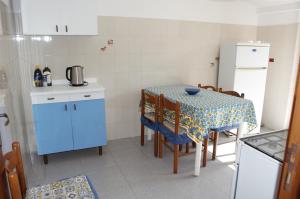 a small kitchen with a table with chairs and a table and a kitchen at Appartamento sul mare in Belmonte Calabro +29 photos