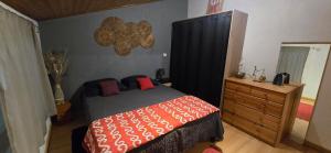 a bedroom with a bed and a wooden dresser at Gite chez kinou in Montans
