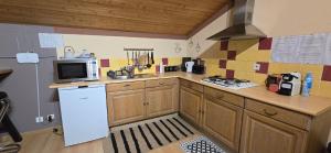 a kitchen with a white refrigerator and a microwave at Gite chez kinou in Montans