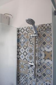 a shower in a bathroom with a tile wall at Appartamento sul mare in Belmonte Calabro