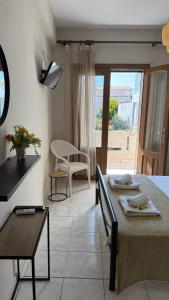 a living room with a table and a room with a window at Roula's Apartment in Limenaria