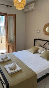 a bedroom with two beds with towels on them at Roula's Apartment in Limenaria