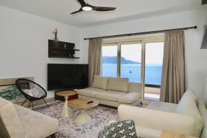 a living room with a couch and a tv at Manolo & Jolie Luxury Villa in Himare