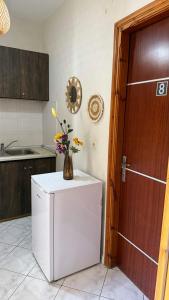 a kitchen with a refrigerator with a vase of flowers on it at Roula's Apartment in Limenaria +13 photos
