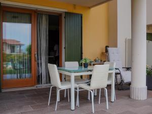 a table and white chairs on a patio at New Home Lazise in Lazise