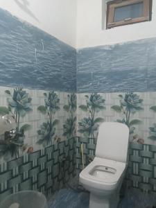 a bathroom with a toilet and plants on the wall at Punchkedar in Phata
