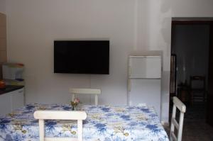 a room with a table with two chairs and a flat screen tv at B&B Sulla Spiaggia in Belmonte Calabro