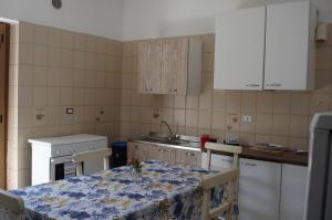 a kitchen with a table with chairs and a sink at B&B Sulla Spiaggia in Belmonte Calabro
