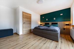 a bedroom with a large bed with a green headboard at Ferienhaus Maarruhe in Schalkenmehren