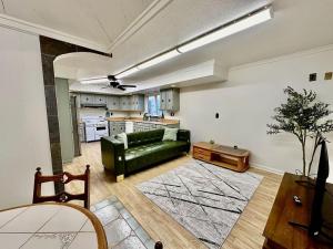 a living room with a green couch and a kitchen at Newly Renovated Quiant 2-bed 2-bath Apt in Wilmington
