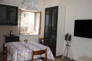 a room with a table and a window and a television at B&B Fronte mare in Belmonte Calabro