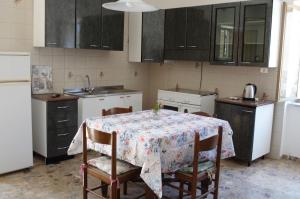 a kitchen with a table and chairs and a refrigerator at B&B Fronte mare in Belmonte Calabro