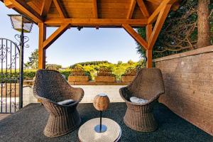 two wicker chairs sitting on a patio with a table at Ferienhaus Maarruhe in Schalkenmehren