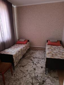 a room with two beds and a chair in it at Yrys quest home in Balykchy