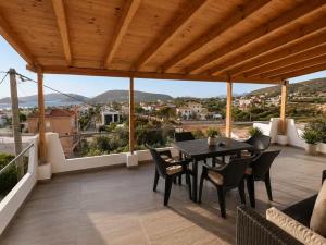 a patio with a table and chairs on a balcony at Panorama in Porto Rafti