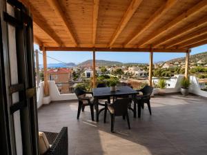 a patio with a table and chairs on a balcony at Panorama in Porto Rafti