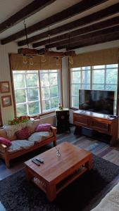 a living room with a couch and a flat screen tv at The Patagonian Lodge in Coihaique
