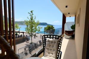 a balcony with a chair and a view of the water at Manolo & Jolie Luxury Villa in Himare