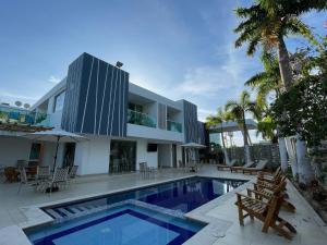 a villa with a swimming pool and a house at Hotel Soleira in Tolú