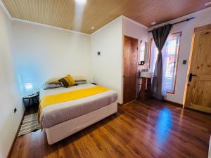 a bedroom with a bed and a wooden floor at Casa Ñawi in San Pedro de Atacama
