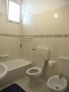 a white bathroom with a toilet and a sink at Valle Verde 4 Clima & Wi-Fi in Castellammare del Golfo +1 photo