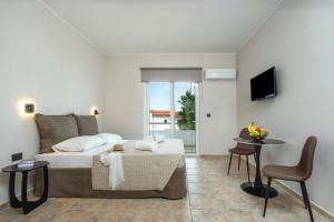a bedroom with a bed and a table and chairs at Sokrates Studios in Afantou +132 photos
